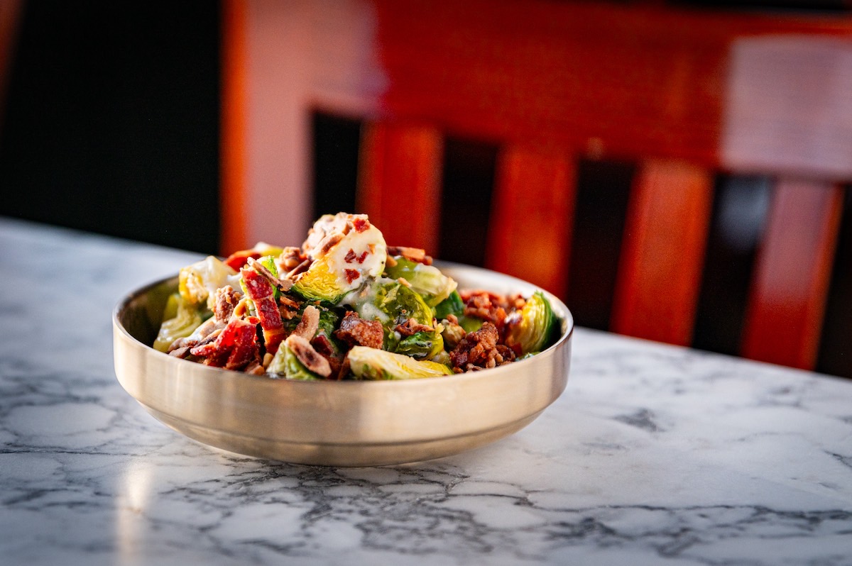 A vibrant bowl of salad placed elegantly on a polished marble table, showcasing fresh ingredients and colors.